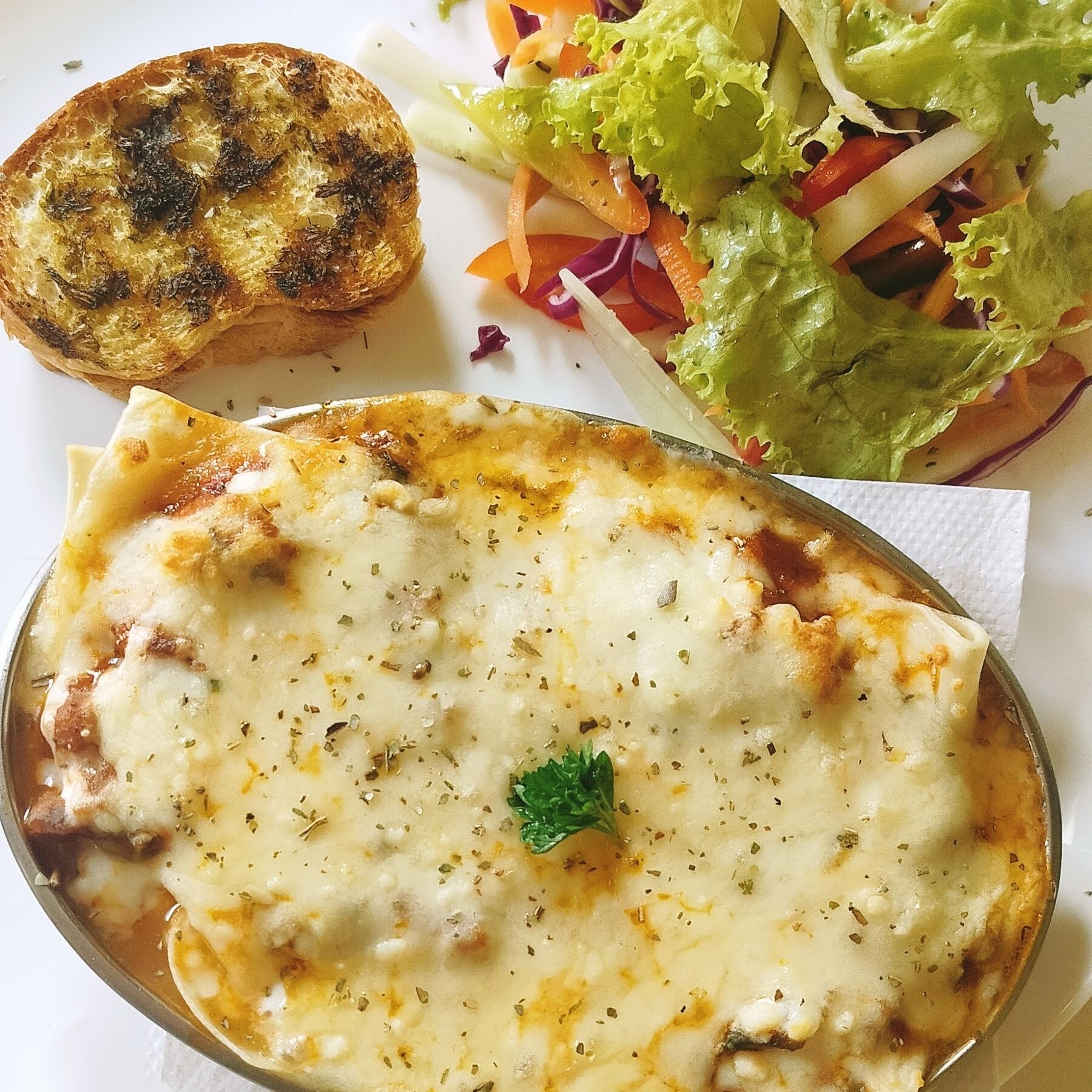 Baked lasagne with garlic bread and salad