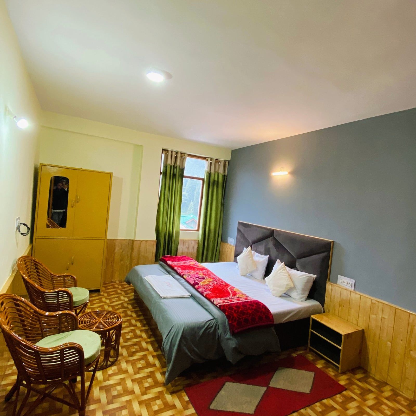 Private double room with a grey feature wall, wicker chair and wardrobe
