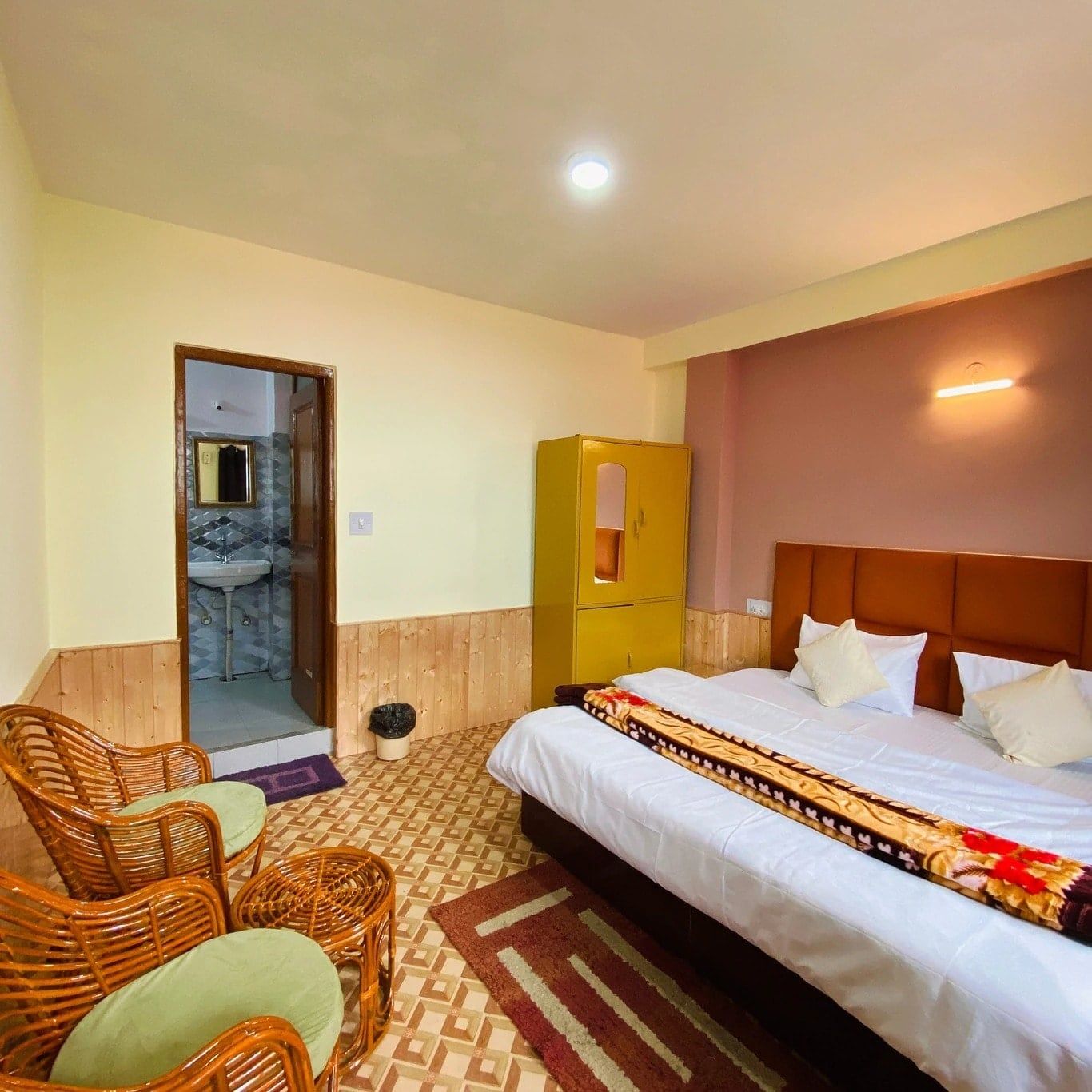 Double room with an attached bathroom and a wicker armchair
